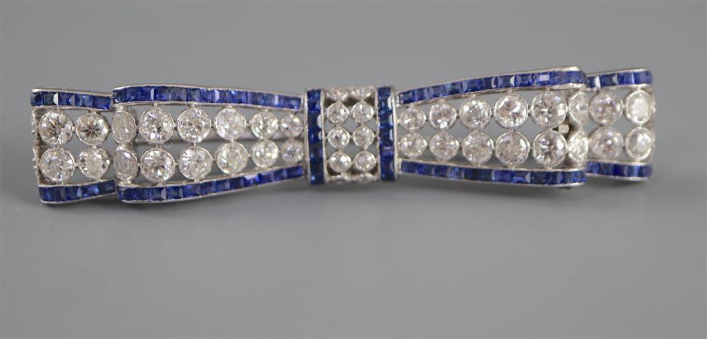 An Art Deco sapphire and diamond bow brooch mounted in white metal,